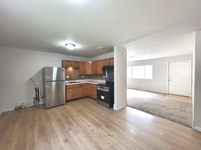 2313 Joppa Ave, Zion, IL 60099 - kitchen with appliances with stainless steel finishes, light countertops, light wood-type flooring, backsplash, and brown cabinetry