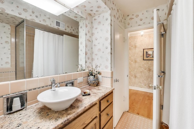 222 Cornell Ave, Des Plaines, IL 60016 - full bath featuring wallpapered walls, vanity, backsplash, wood finished floors, and a shower with shower curtain
