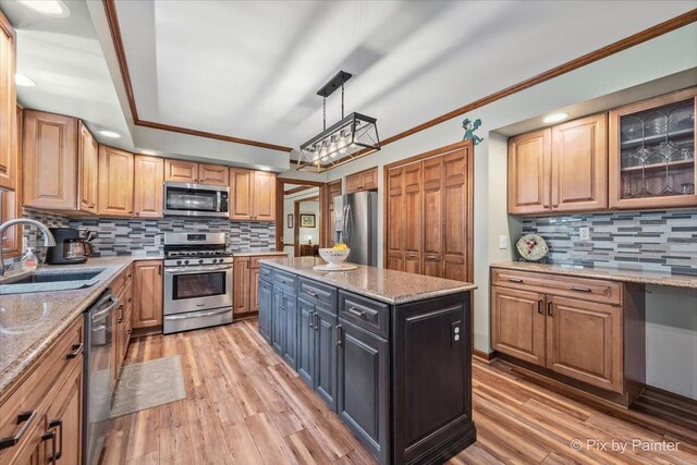 2N445 Beith Rd, Elburn, IL 60119 - kitchen with appliances with stainless steel finishes, backsplash, light wood-type flooring, a center island, and crown molding
