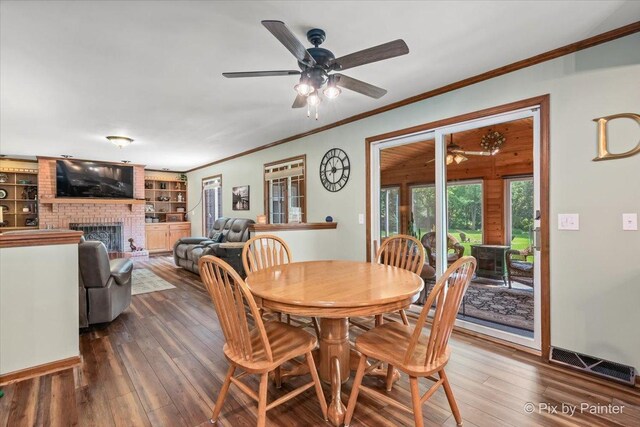 2N445 Beith Rd, Elburn, IL 60119 - dining area with ceiling fan, crown molding, dark wood-style flooring, and a fireplace