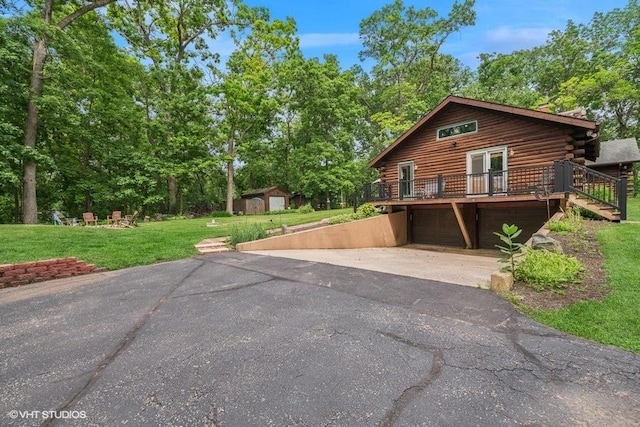 N1508 Wildwood Rd, Linn, WI 53147 - log-style house featuring log siding, driveway, a garage, a front lawn, and a wooden deck