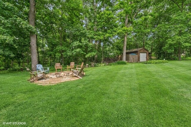 N1508 Wildwood Rd, Linn, WI 53147 - view of grassy yard with a fire pit, an outdoor structure, and a detached garage