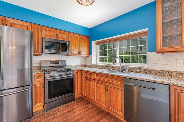 31 E Shagbark Ln, Streamwood, IL 60107 - kitchen with appliances with stainless steel finishes, dark wood finished floors, light stone countertops, brown cabinets, and tasteful backsplash