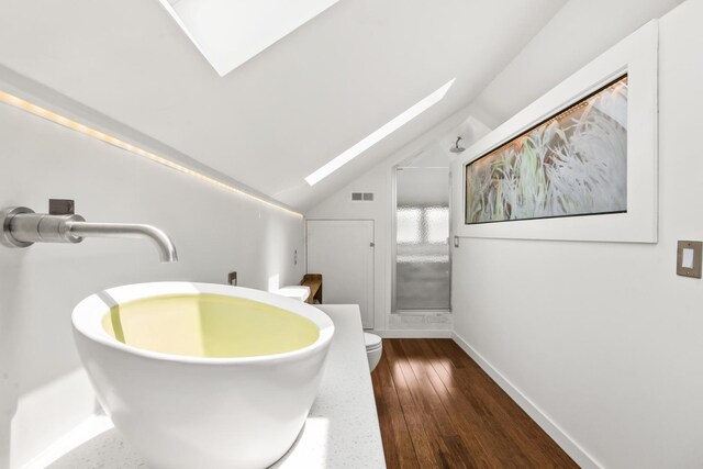 7439 N Maplewood Ave, Chicago, IL 60645 - bathroom with a skylight, vaulted ceiling, and wood-type flooring
