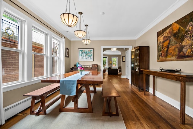 7439 N Maplewood Ave, Chicago, IL 60645 - dining area featuring dark wood-type flooring, arched walkways, crown molding, and a baseboard heating unit