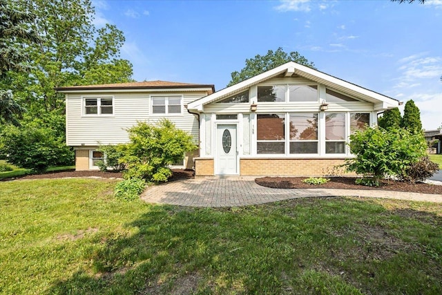 145 N Oakleaf Dr, Addison, IL 60101 - split level home featuring brick siding, a front yard, a patio area, and a sunroom