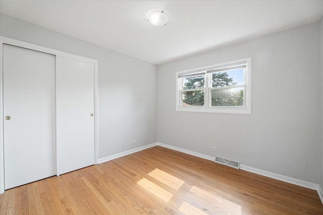 145 N Oakleaf Dr, Addison, IL 60101 - unfurnished bedroom featuring light wood-style floors and a closet