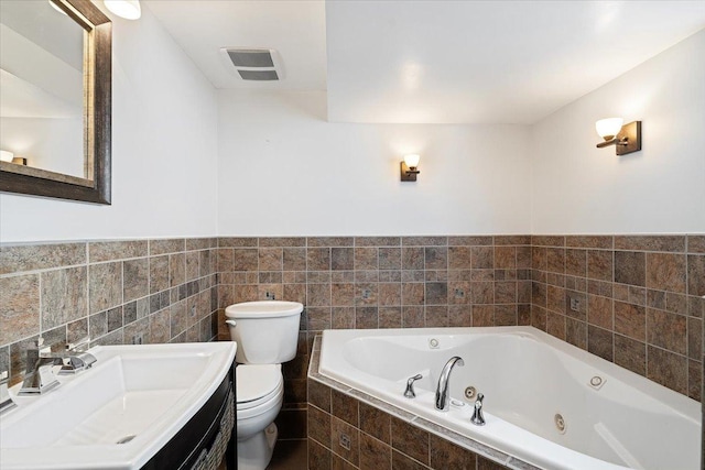 145 N Oakleaf Dr, Addison, IL 60101 - bathroom featuring a tub with jets, tile walls, vanity, and a wainscoted wall