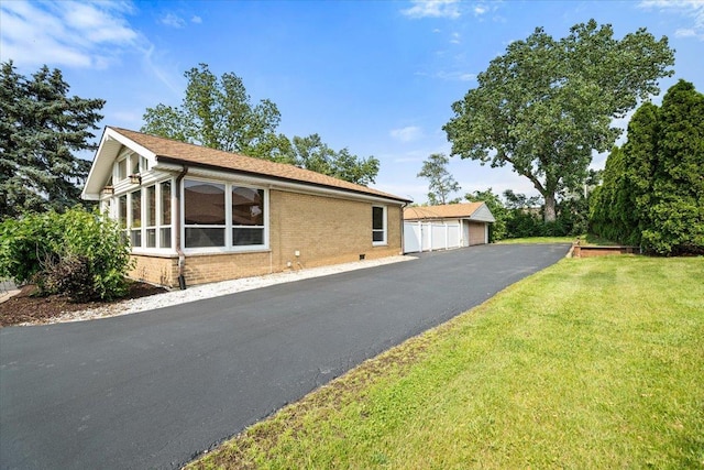 145 N Oakleaf Dr, Addison, IL 60101 - view of front facade featuring brick siding, a detached garage, a front yard, and an outbuilding