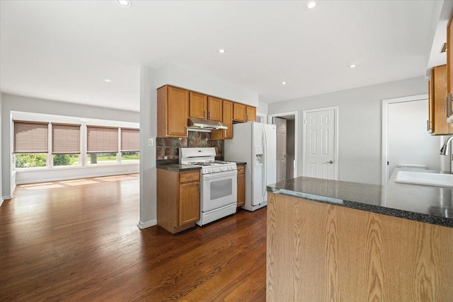 145 N Oakleaf Dr, Addison, IL 60101 - kitchen with white appliances, under cabinet range hood, dark wood-style flooring, tasteful backsplash, and brown cabinetry