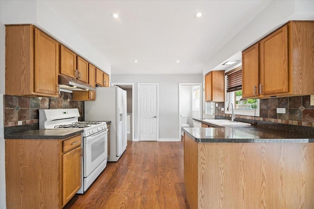 145 N Oakleaf Dr, Addison, IL 60101 - kitchen featuring white appliances, under cabinet range hood, dark wood-type flooring, a peninsula, and decorative backsplash