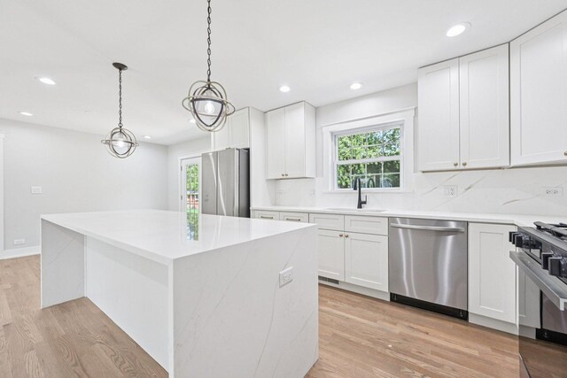 6933 Parkview Dr, Downers Grove, IL 60516 - kitchen featuring appliances with stainless steel finishes, healthy amount of natural light, a center island, light wood-style floors, and recessed lighting