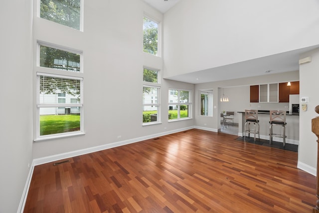 905 Huntington Dr, Elk Grove Village, IL 60007 - unfurnished living room featuring wood finished floors, healthy amount of natural light, and a towering ceiling