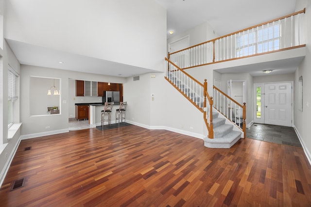 905 Huntington Dr, Elk Grove Village, IL 60007 - unfurnished living room featuring a towering ceiling, dark wood-type flooring, stairs, and recessed lighting