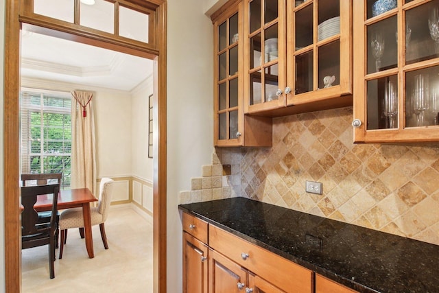 1560 Fairway Cir, Geneva, IL 60134 - kitchen featuring ornamental molding, dark stone counters, a tray ceiling, wainscoting, and tasteful backsplash