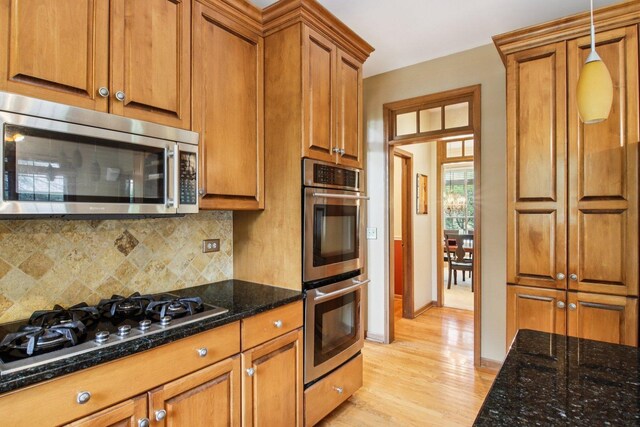 1560 Fairway Cir, Geneva, IL 60134 - kitchen with appliances with stainless steel finishes, brown cabinets, light wood-style flooring, tasteful backsplash, and dark stone countertops