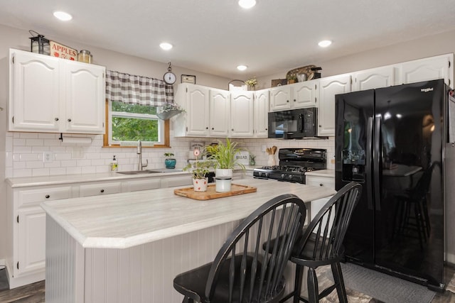 1608 Surrey St, Normal, IL 61761 - kitchen with black appliances, white cabinets, light countertops, backsplash, and recessed lighting