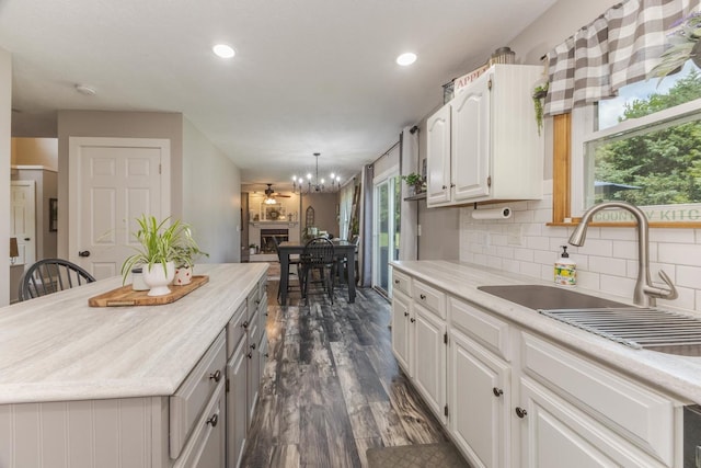 1608 Surrey St, Normal, IL 61761 - kitchen with light countertops, dark wood finished floors, white cabinetry, decorative backsplash, and plenty of natural light