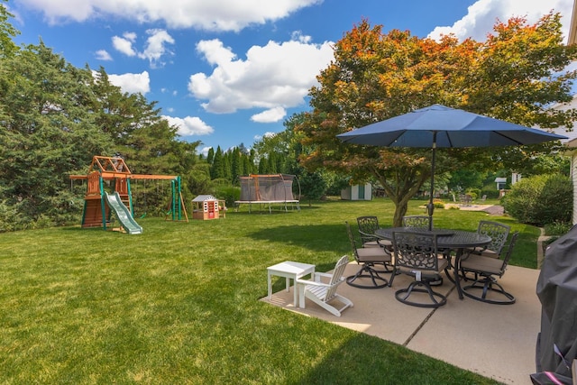 1608 Surrey St, Normal, IL 61761 - view of green lawn featuring a trampoline, a playground, a patio, outdoor dining area, and a storage shed