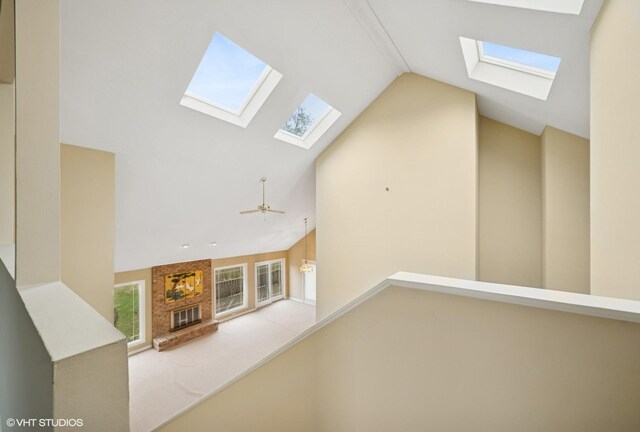 13 Chipping Campden Dr, South Barrington, IL 60010 - unfurnished living room featuring a skylight, a brick fireplace, a ceiling fan, and high vaulted ceiling