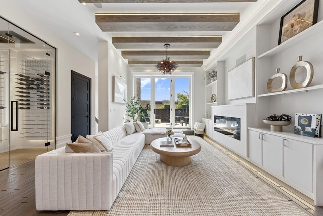 2756 N Magnolia Ave Unit Ph, Chicago, IL 60614 - living area with beam ceiling, built in shelves, a glass covered fireplace, and wood finished floors