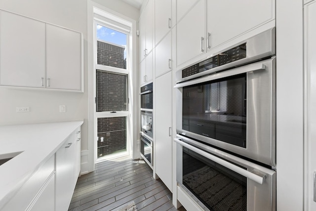 2756 N Magnolia Ave Unit Ph, Chicago, IL 60614 - kitchen featuring double oven, white cabinets, light countertops, and wood finished floors
