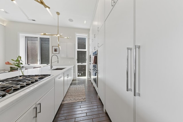 2756 N Magnolia Ave Unit Ph, Chicago, IL 60614 - kitchen featuring appliances with stainless steel finishes, white cabinets, dark wood-style flooring, and light countertops