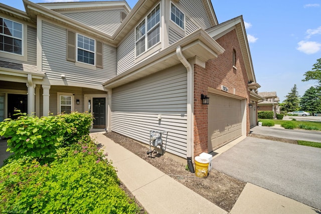 2026 Juniper Ct, Glendale Heights, IL 60139 - view of side of home with brick siding, a garage, and driveway