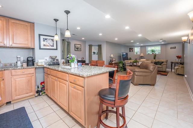 2115 N Sawyer Ave, Chicago, IL 60647 - kitchen with light tile patterned flooring, a kitchen breakfast bar, a peninsula, open floor plan, and light stone countertops