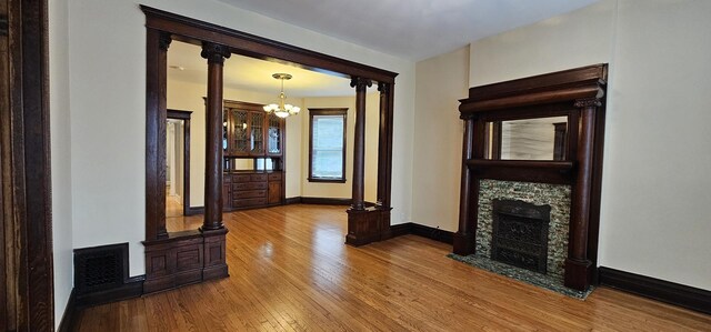 2115 N Sawyer Ave, Chicago, IL 60647 - unfurnished living room featuring a chandelier, hardwood / wood-style floors, and a fireplace