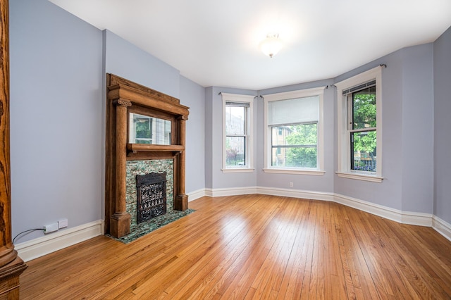 2115 N Sawyer Ave, Chicago, IL 60647 - unfurnished living room with light wood finished floors and a tile fireplace