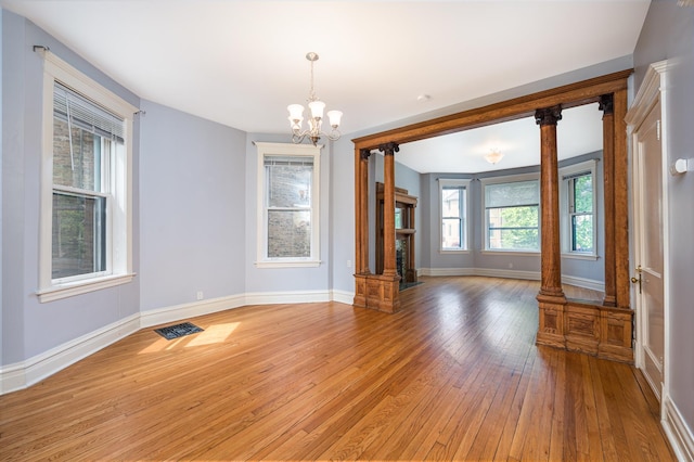 2115 N Sawyer Ave, Chicago, IL 60647 - unfurnished room featuring light wood-style floors, a chandelier, and a fireplace