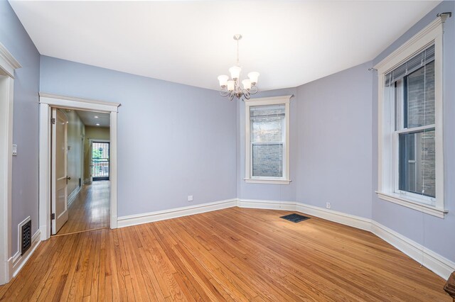2115 N Sawyer Ave, Chicago, IL 60647 - empty room featuring a chandelier and light wood-style flooring