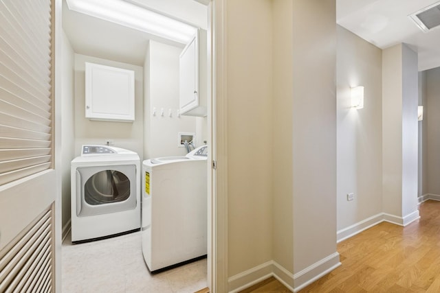 310 S Michigan Ave Unit 1804, Chicago, IL 60604 - washroom with cabinet space, separate washer and dryer, and light wood-style floors
