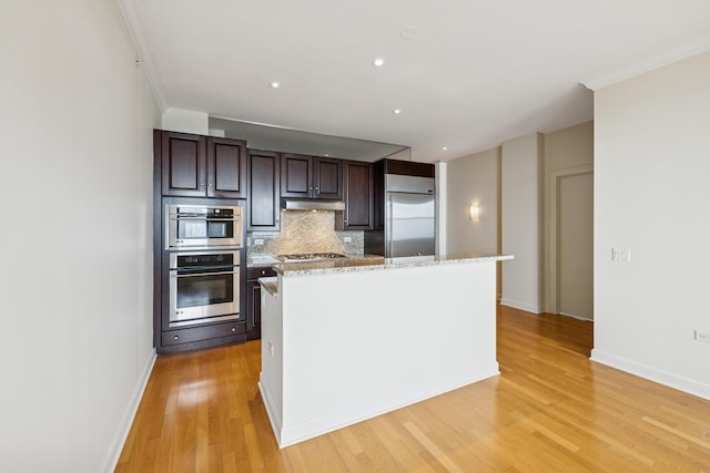 310 S Michigan Ave Unit 1804, Chicago, IL 60604 - kitchen featuring stainless steel appliances, under cabinet range hood, light wood-type flooring, decorative backsplash, and dark brown cabinetry