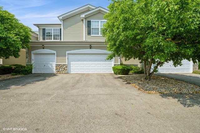 2733 Kendall Xing, Johnsburg, IL 60051 - view of front facade with asphalt driveway, an attached garage, and stone siding