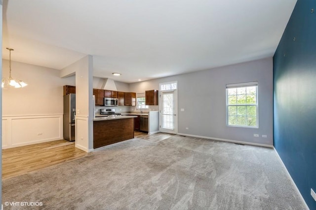 2733 Kendall Xing, Johnsburg, IL 60051 - unfurnished living room featuring light carpet, healthy amount of natural light, and a chandelier
