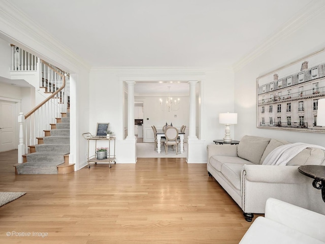 551 W 3rd St, Elmhurst, IL 60126 - living area with light wood finished floors, ornate columns, ornamental molding, stairway, and a chandelier