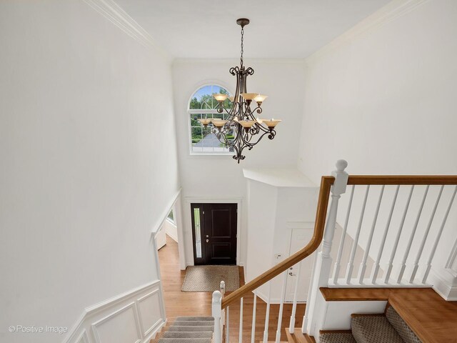 551 W 3rd St, Elmhurst, IL 60126 - stairway featuring a chandelier, crown molding, wood finished floors, and a wainscoted wall