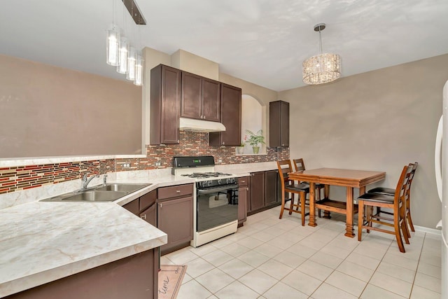 8808 Concord Ln Unit J, Justice, IL 60458 - kitchen featuring gas range oven, under cabinet range hood, decorative backsplash, light countertops, and light tile patterned floors
