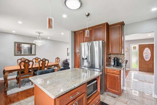 9342 Oriole Ave, Morton Grove, IL 60053 - kitchen featuring appliances with stainless steel finishes, light stone countertops, pendant lighting, recessed lighting, and brown cabinetry