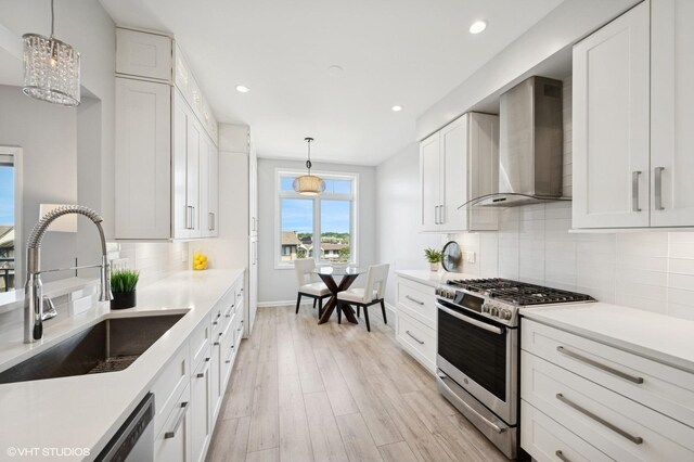 11 S Wille St Unit 709, Mount Prospect, IL 60056 - kitchen featuring stainless steel appliances, wall chimney range hood, light wood-style floors, recessed lighting, and white cabinetry