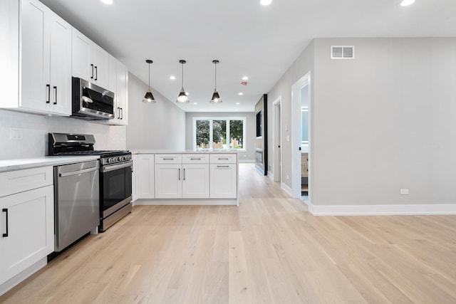 2563 Maple St, River Grove, IL 60171 - kitchen with stainless steel appliances, a peninsula, light wood-style floors, white cabinets, and recessed lighting