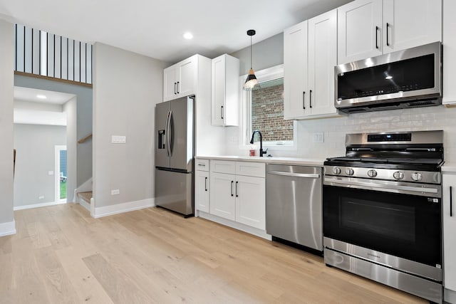 2563 Maple St, River Grove, IL 60171 - kitchen with appliances with stainless steel finishes, light wood-type flooring, tasteful backsplash, light countertops, and white cabinets