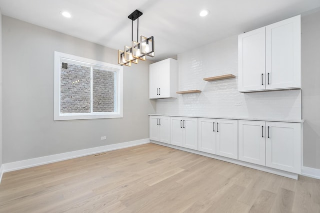 2563 Maple St, River Grove, IL 60171 - kitchen with light wood-style floors, a chandelier, tasteful backsplash, open shelves, and white cabinetry