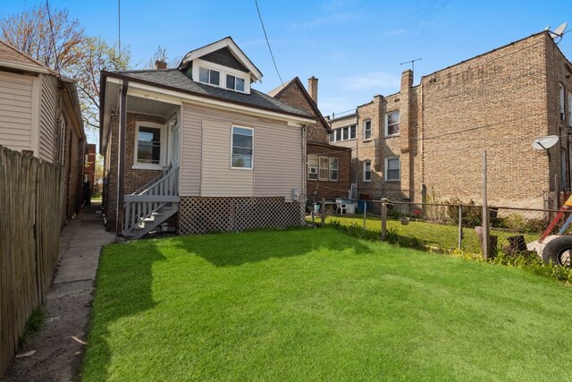 5407 S Justine St, Chicago, IL 60609 - rear view of property with entry steps, a fenced backyard, and a shingled roof