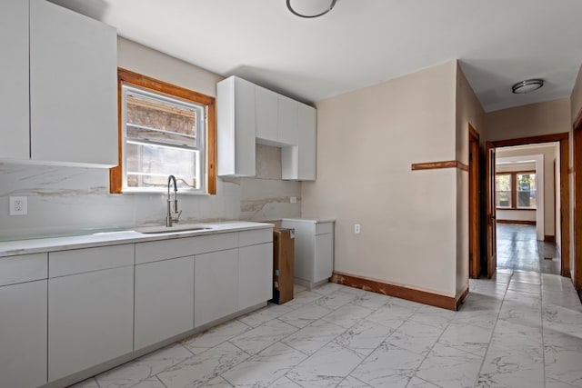 5407 S Justine St, Chicago, IL 60609 - kitchen featuring light marble finish flooring, light countertops, white cabinetry, and decorative backsplash