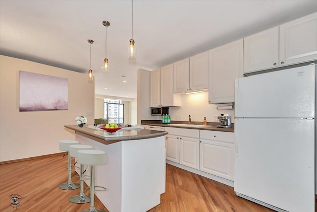 910 S Michigan Ave Unit 1712, Chicago, IL 60605 - kitchen with freestanding refrigerator, dark countertops, light wood-style floors, white cabinetry, and recessed lighting