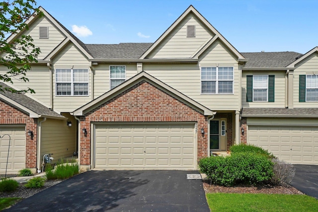 5227 Cobblers Xing Unit 5227, Mchenry, IL 60050 - view of property featuring asphalt driveway, brick siding, a shingled roof, and a garage