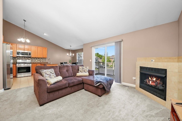 5227 Cobblers Xing Unit 5227, Mchenry, IL 60050 - living area featuring a chandelier, vaulted ceiling, light carpet, and a tiled fireplace